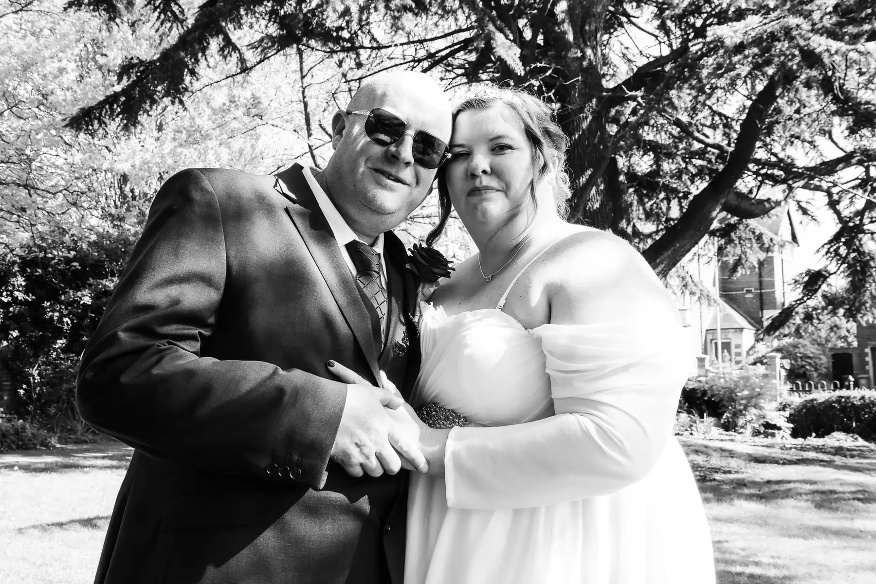 Bride and groom posing together in a garden at Kettering Registry Office, captured in a natural documentary wedding photography style in Northamptonshire