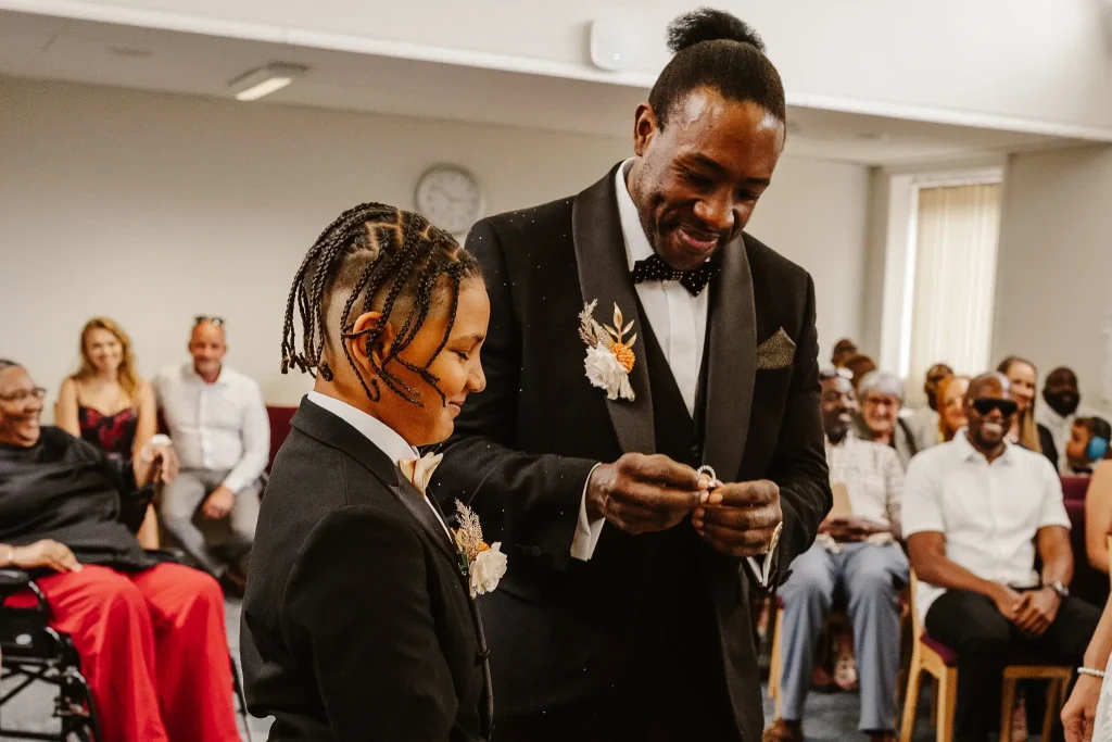 Young ring bearer standing beside the groom as the wedding rings are presented during a civil ceremony at Beaconsfield Registry Office, Buckinghamshire