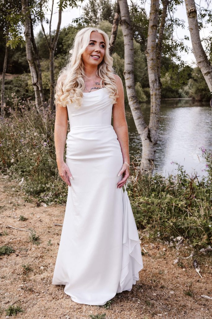 Bride in wedding dress beside the lake at Hellidon Lakes Hotel & Resort