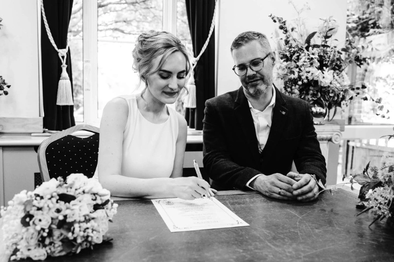 Bride signing the marriage register with her groom at Maidenhead Registry Office in Berkshire