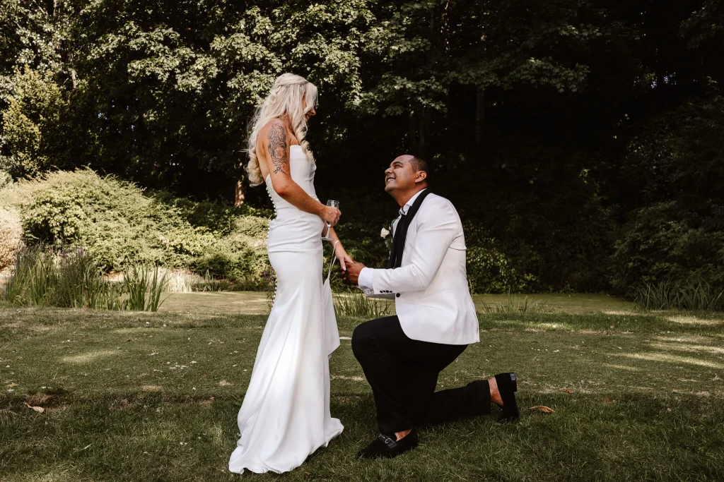 Groom getting down on one knee with his bride at Hellidon Lakes Hotel & Resort